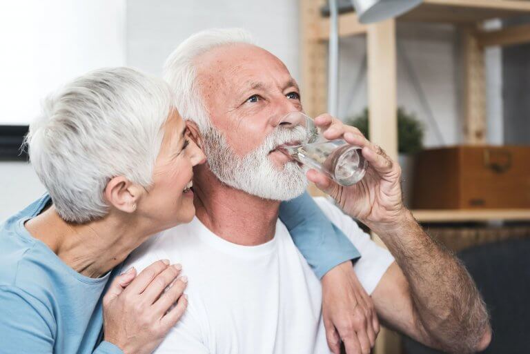 People who are drinking out of a water glass